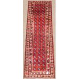 Persian Baluch runner rug, red ground with repeating Gul motifs,