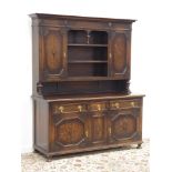 Early 20th century oak dresser, projecting cornice above two geometric cupboards and centre shelves,