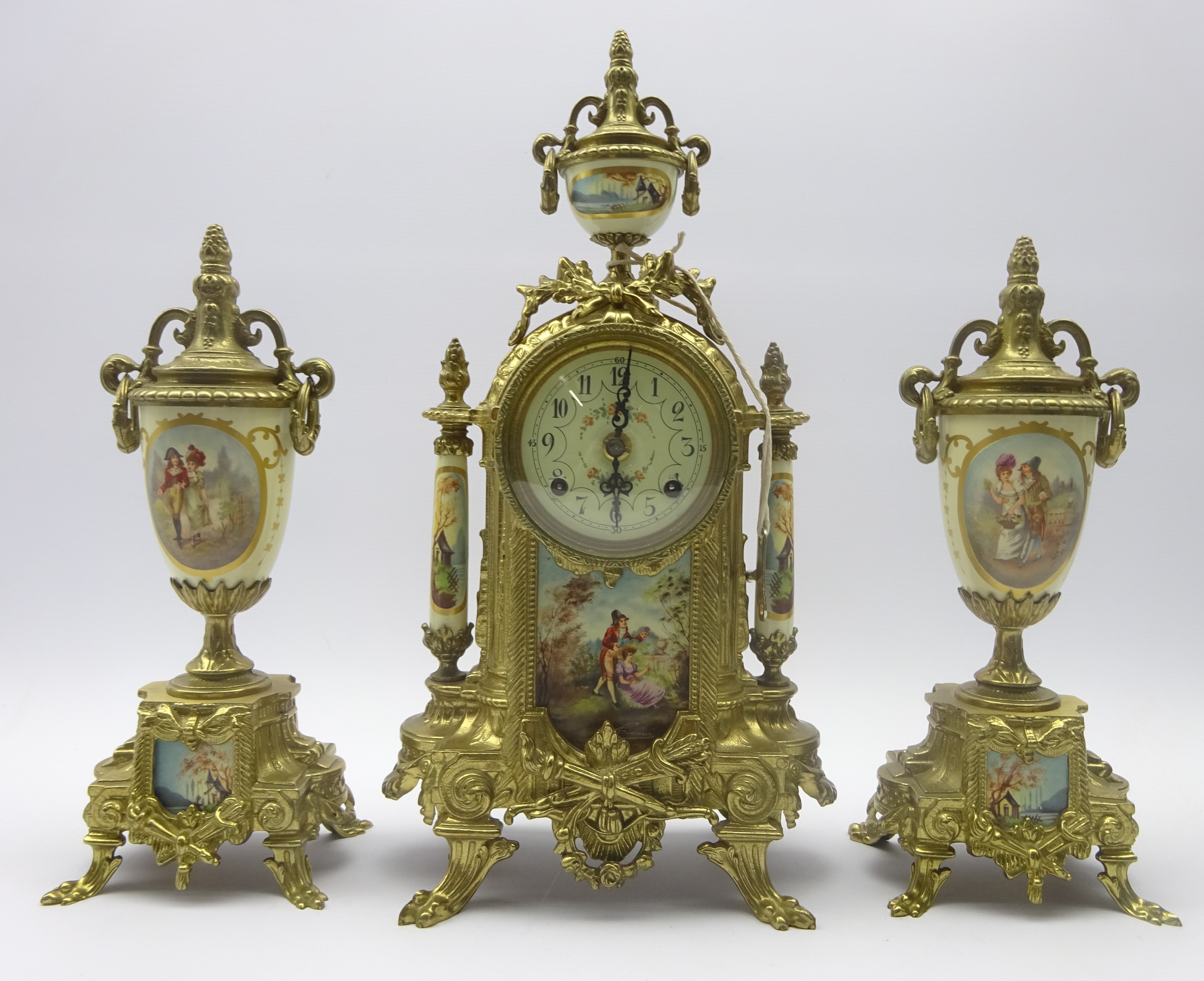 French gilt metal clock with garniture, urn finial above circular Arabic dial,