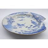 18th Century English Delft charger decorated in blue and white with a Chinese figure, dog,