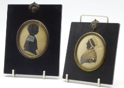 Early 19th Century oval silhouette of a lady wearing a mob cap and another of a child,