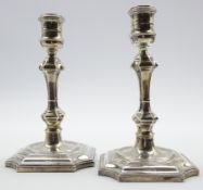 Pair of Georgian design silver candlesticks with tapering stems and indented square bases H19cms
