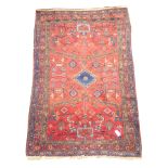 Persian Hamadan red ground rug, stepped lozenge medallion, geometric and stylised motifs,