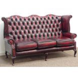 Georgian style three seat wingback settee, upholstered in deeply buttoned ox-blood leather,