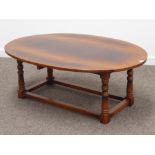 Medium oak oval drop leaf coffee table, turned supports joined by stretchers, 122cm x 86cm,