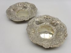 Pair of late Victorian silver circular dishes with embossed leaf and flower head decoration D23cm