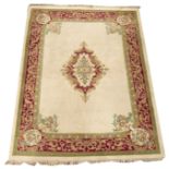 Large Indian design wool beige ground rug, central floral medallion on beige field,
