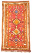 Tribal woollen red ground rug, quadruple lozenge medallion, stylised motifs, repeating boarder,