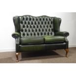 Georgian style two seat wing back settee, upholstered in deeply buttoned green leather,