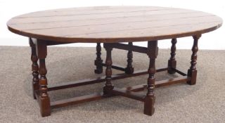 17th century style oak drop leaf coffee table, planked oval top over turned supports,