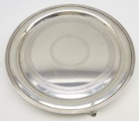 Silver circular salver with engraved decoration and reeded border on triple shaped supports