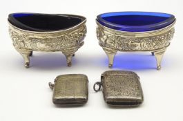 Pair of George III silver navette shape salts with embossed decoration and blue glass liners London