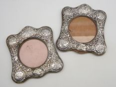 Pair of Edwardian silver photograph frames with embossed cherub and floral decoration on easel