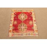 Persian Heriz rug, double medallion on red field, repeating geometric motif to border,