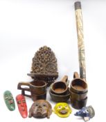 Five carved and painted Eastern face masks, carved wall bracket, didgeridoo,