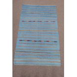 Flat woven blue ground rug, with multi coloured linear design,