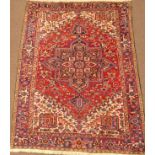 Persian Heriz red and blue ground rug, central medallion on red field, ivory spandrels,