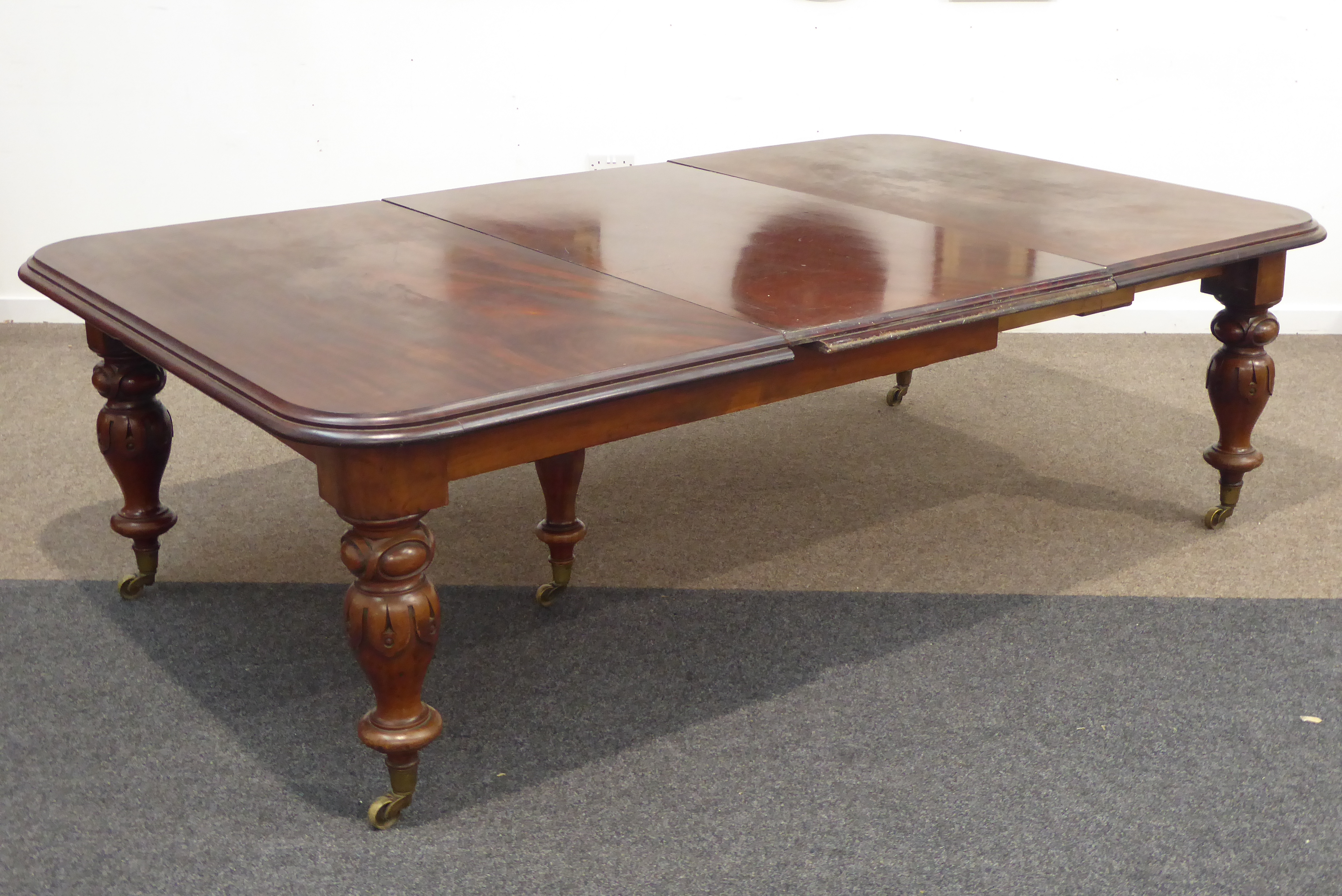 Large Victorian mahogany extending dining table, rectangular moulded top having rounded corners,