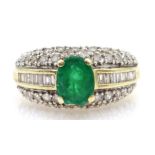 Gold oval emerald ring, with baguette and round brilliant cut diamond shoulders, stamped 14K,