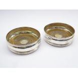 Pair of George III silver wine coasters with turned boxwood bases and an engraved crest D13cm