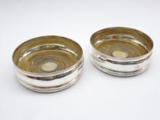Pair of George III silver wine coasters with turned boxwood bases and an engraved crest D13cm
