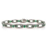 White gold round and calibre cut emerald and round brilliant cut diamond link bracelet,