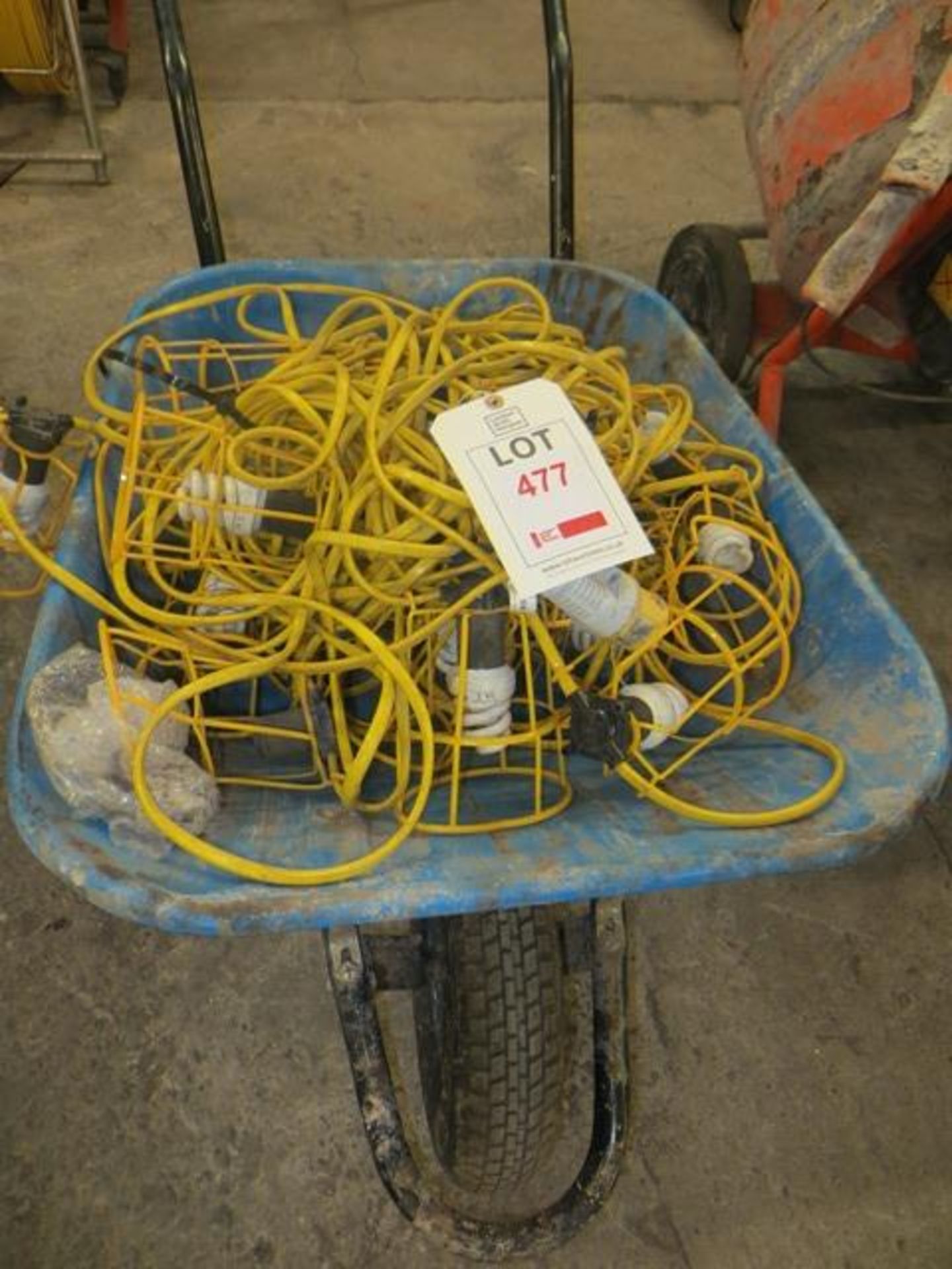 Wheelbarrow containing various 110V cage surrounded work lights as lotted
