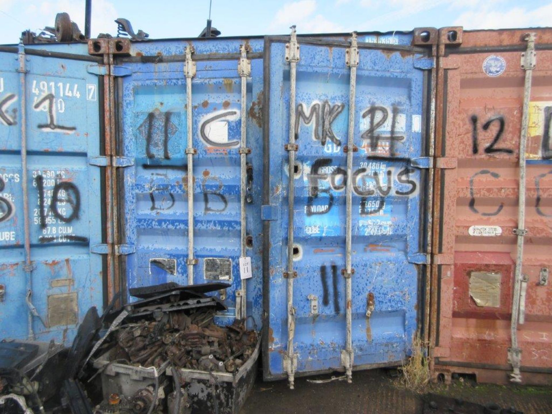 Blue steel shipping container, 40 ft. x 8 ft. approx. plus rack and contents of mainly Ford Focus