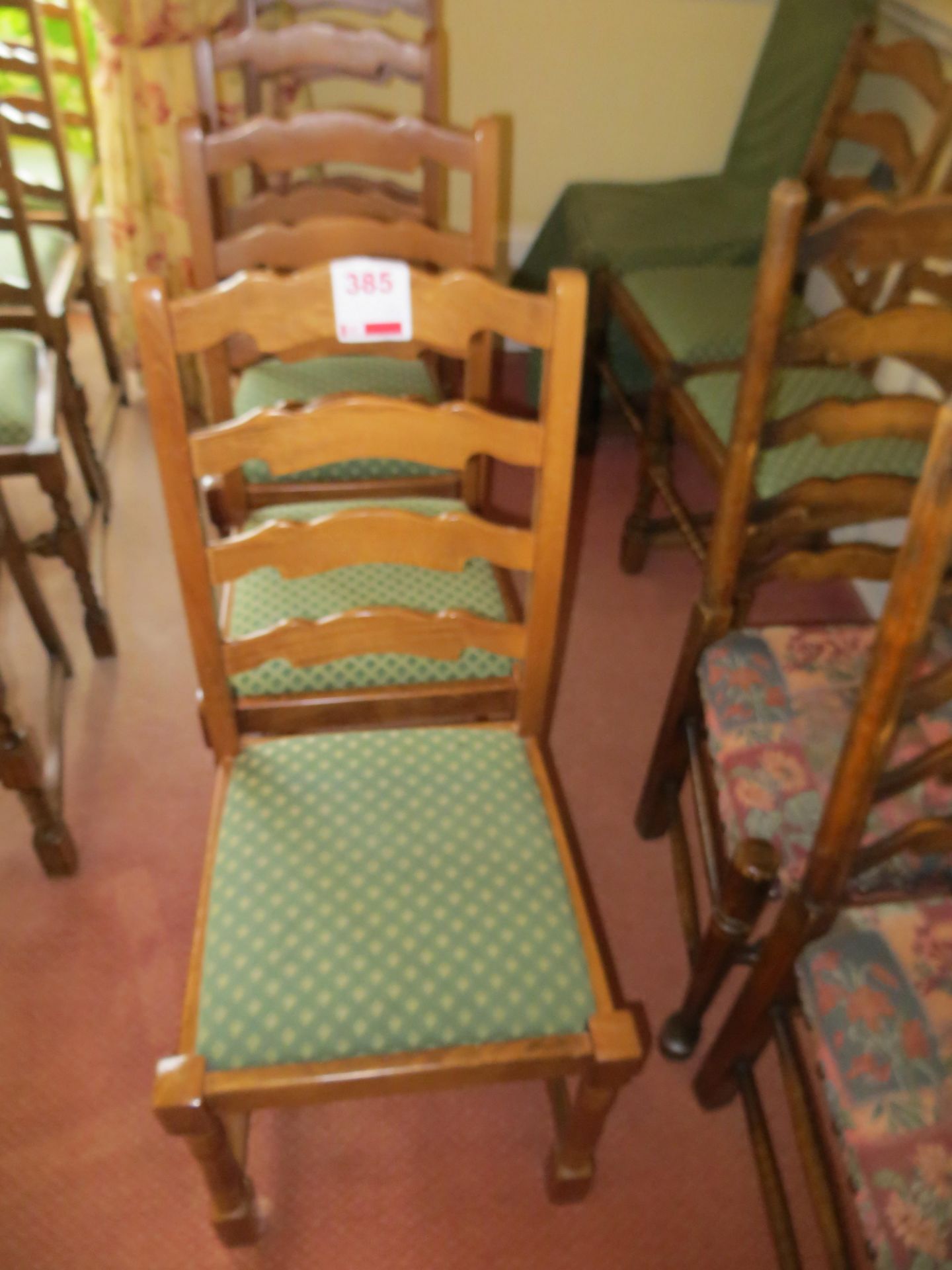 Four matching green cloth dining chairs