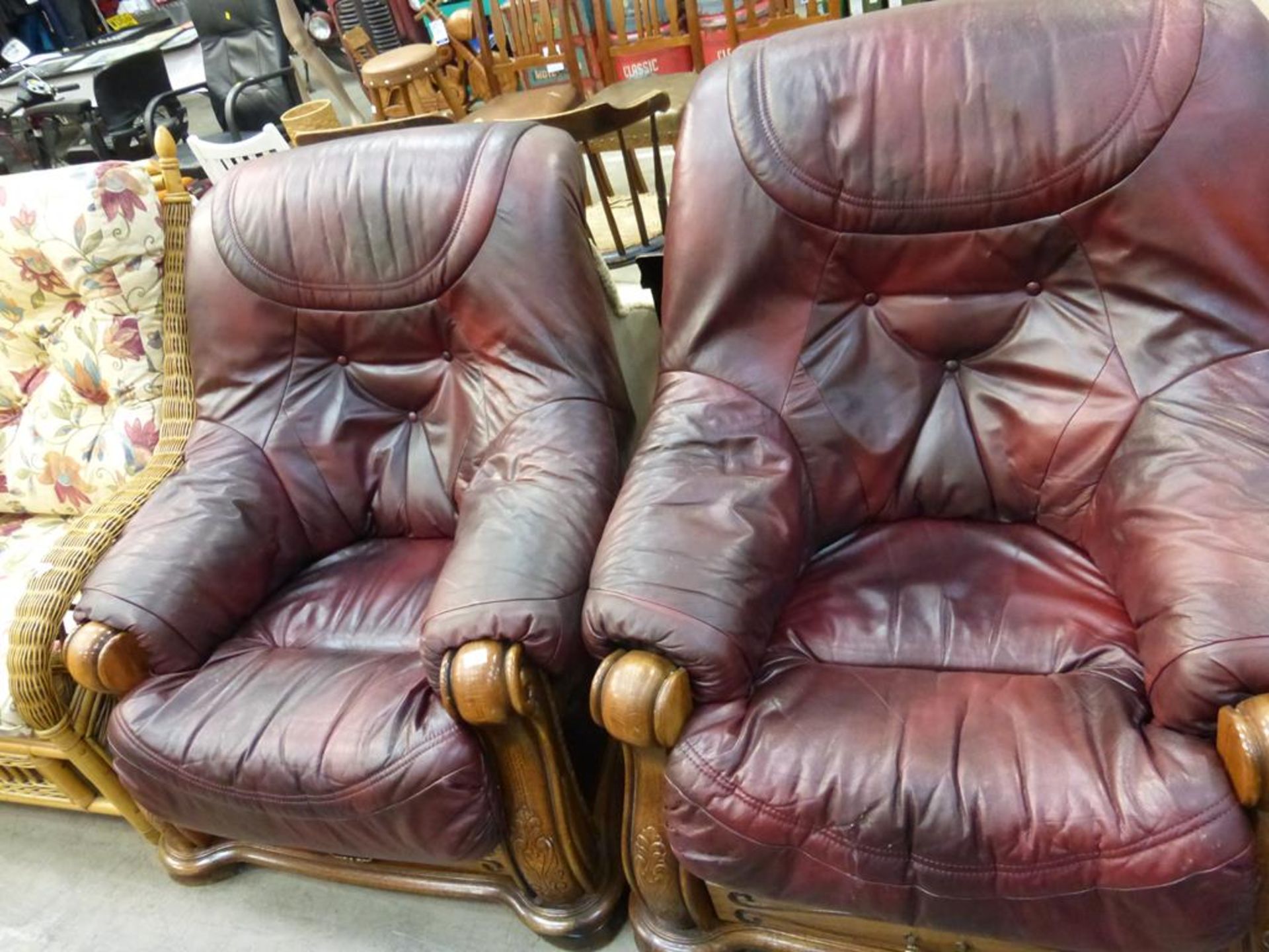 A pair of red leather upholstered deep button back Armchairs with show-wood arms and frame (