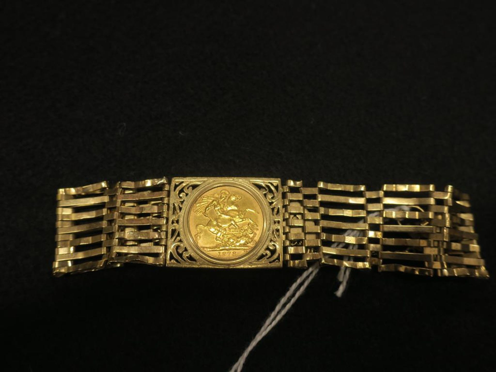 An Elizabeth II 1978 Full Sovereign Loosely Mounted Within a 9ct Gold Gate Bracelet. Total Weight (