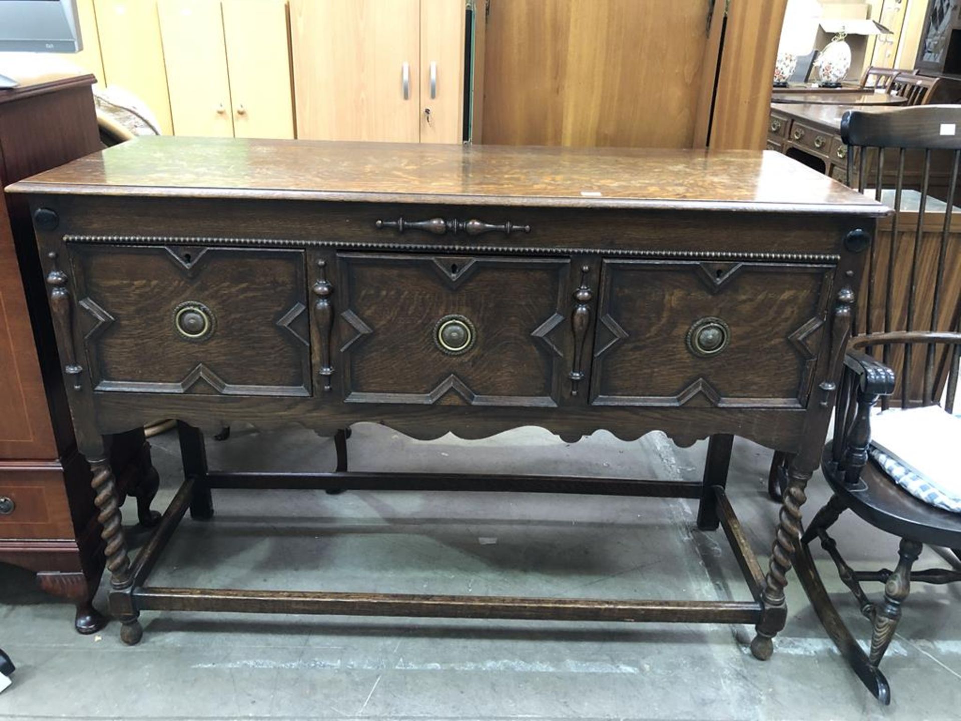 A Pre-War Oak Sideboard of Jacobean design with deep single drawer flanked by cupboards on barley