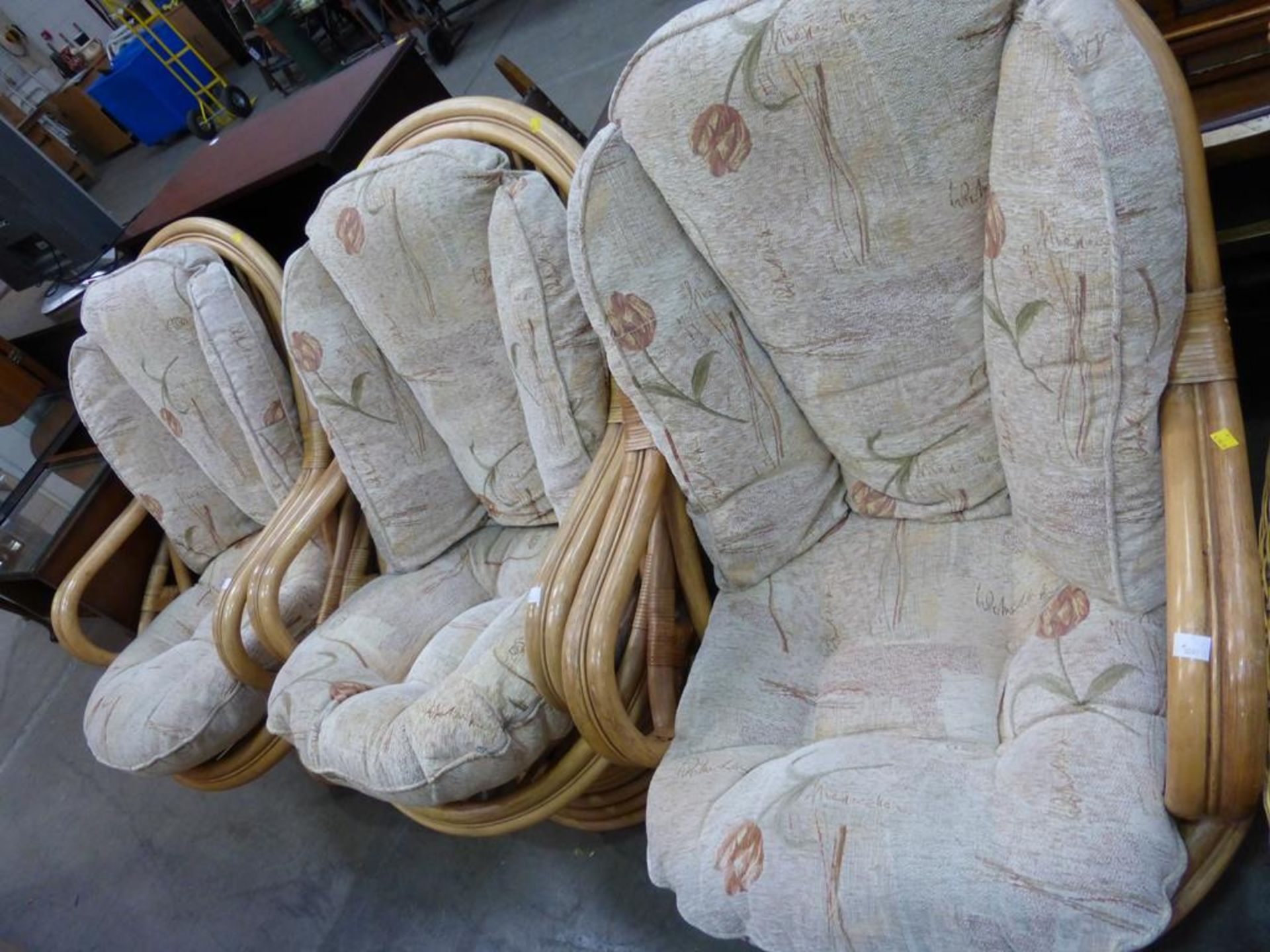 A set of three large cane framed Swivel Conservatory Armchairs each with loose cushions (est £