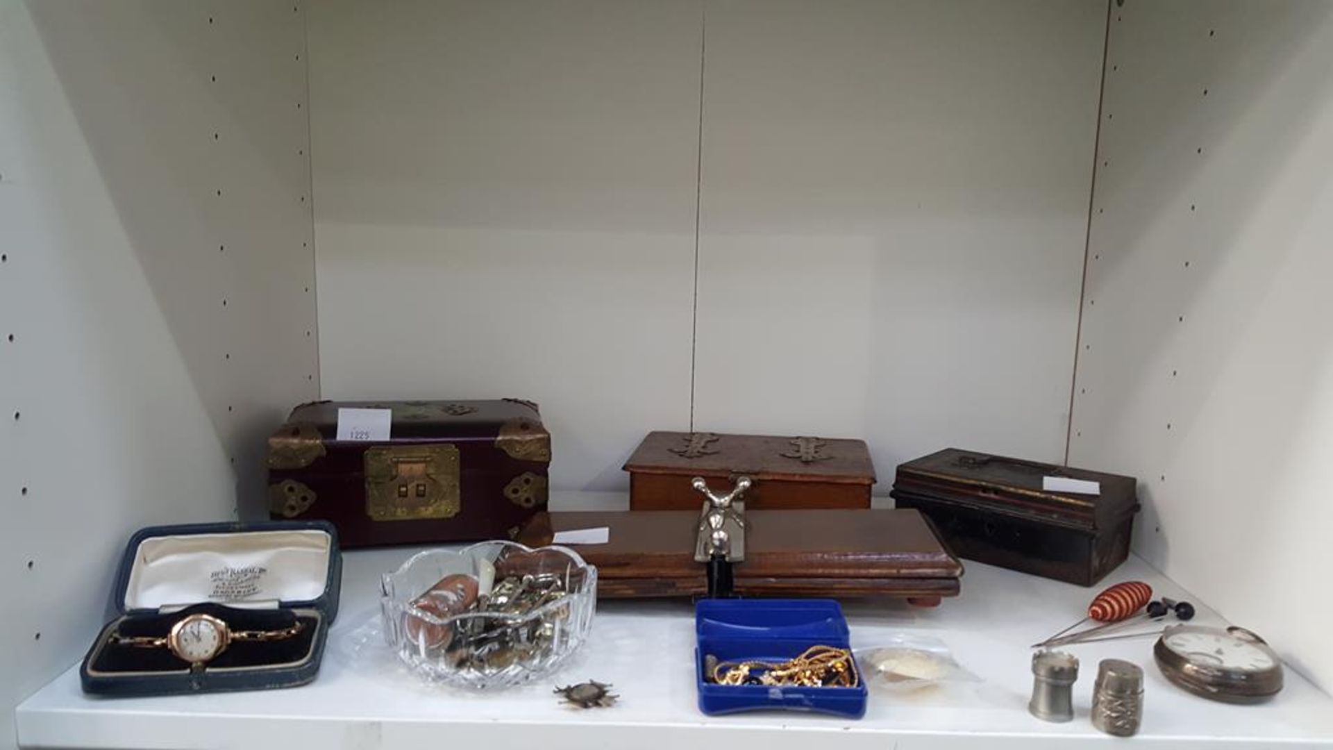 A shelf of assorted items to include a 9ct Gold Wristwatch (plated bracelet), Silver Pocket Watch (