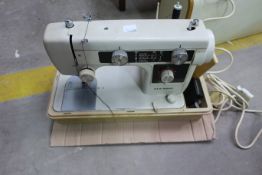 An Electric New Home Sewing Machine with cover (est £20-£40)