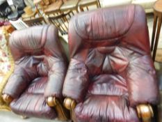 A pair of red leather upholstered deep button back Armchairs with show-wood arms and frame (