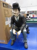 Sitting Charlie Chaplin Figure on metal chair together with a Lady in Housemaid Uniform Figurine
