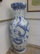 A Large, Blue and White Glazed Oriental Vase decorated with raised mythical figures, marked to the