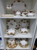 Four shelves containing over seventy five pieces of Royal Albert 'Old Country Roses' including