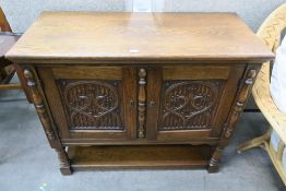 A Reproduction Oak Side Cabinet with two carved pa