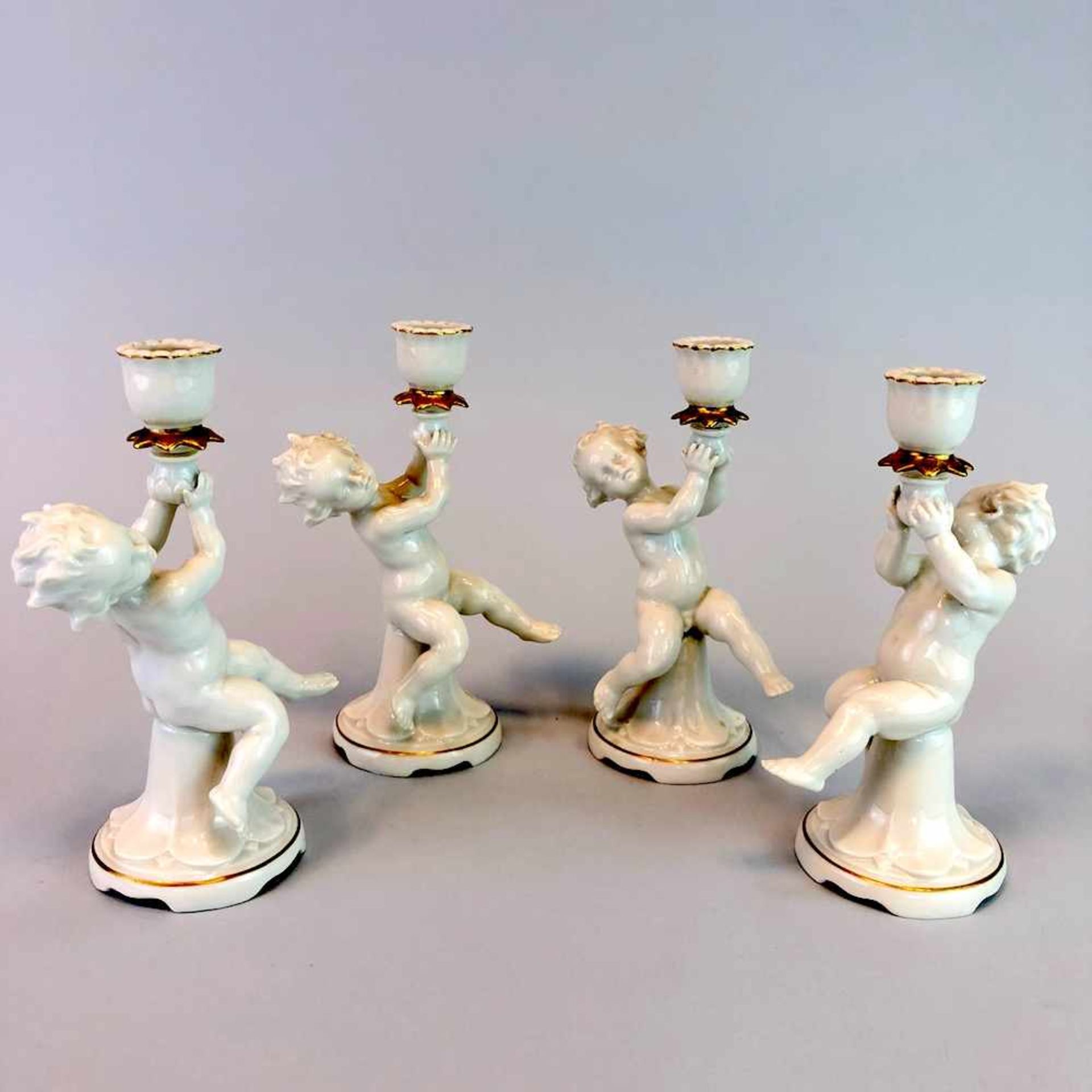 Vier Engel / Putten als Kerzenträger. Metzler & Ortloff in Ilmenau, um 1900.Porzellan, weiß