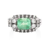 AN EMERALD AND DIAMOND DRESS RING in 18ct white gold, the central emerald cut emerald of