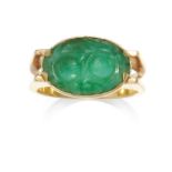 A CARVED JADEITE JADE DRESS RING in high carat yellow gold, set with an oval carved piece of jade,