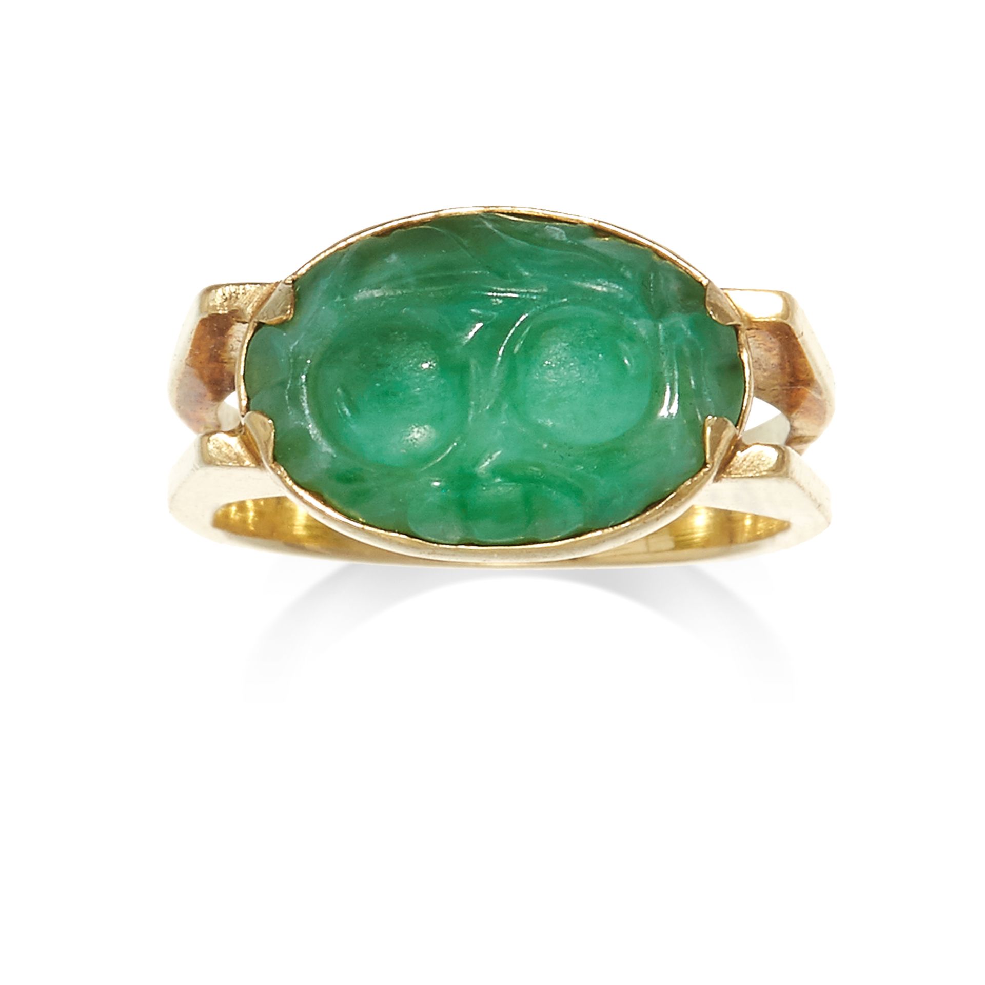 A CARVED JADEITE JADE DRESS RING in high carat yellow gold, set with an oval carved piece of jade,