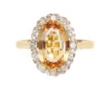 AN IMPERIAL TOPAZ AND DIAMOND RING in 18ct yellow gold, oval cut imperial topaz of 3.10 carats