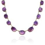 AN AMETHYST RIVIERA NECKLACE in high carat yellow gold, comprising a single row of twenty two oval
