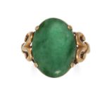 A JADE DRESS RING in high carat yellow gold, the polished oval jade cabochon set between scrolling