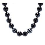 A BANDED AGATE BEAD NECKLACE comprising a single row of twenty two banded agate beads of 18-19mm