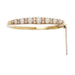 AN ANTIQUE NATURAL PEARL AND DIAMOND BANGLE in high carat yellow gold set with a row of