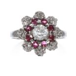 A DIAMOND AND RUBY RING in 18ct white gold, the central round cut diamond of approximately 0.50